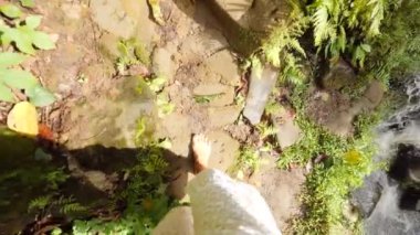İlk kişi görünümü: Tropikal ormanda vahşi şelale, çıplak ayakla yürümek beyaz elbiseli kadın. Sakin ve kaygısız yaşam tarzı seyahat 4k Slowmotion görüntüleri. Bali, Endonezya.