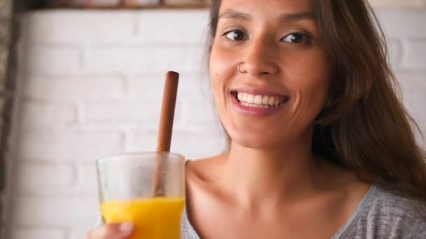 Atraktivní mladá usmívající se smíšené dívka pití Mango a Vegan superpotraviny Smoothie nápoj. 4 k Slowmotion koncept zdravého životního stylu. Ubud, Bali, Indonésie. — Stock video