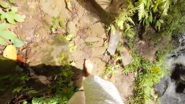 Vista en primera persona: Mujer vestida de blanco caminando descalza en la cascada salvaje en la selva tropical. Calm and Carefree Lifestyle Travel 4K Slowmotion Filmación. Bali, Indonesia . — Vídeo de stock