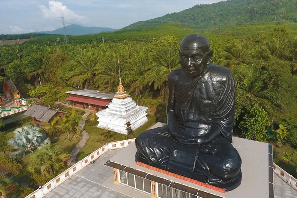 Black Buddhist Sitting Meditation Monk Statue. Wat Kaeo Manee Si Mahathat Temple. Aerial Shot from Above. Phang Nga Province, Thailand.
