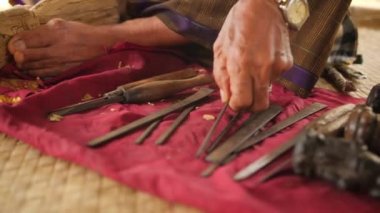 Woodcarver oyma ahşap iş parçası üzerinde keskin aletler ile yapıyor. Geleneksel Balinese heykelciği yapma işlemi. 4 k. Bali, Endonezya