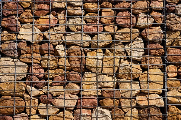 Gabion walls are a low cost economical construction method for building walls and garden retaining walls made by stacking rocks and stones in a steel mesh cage.
