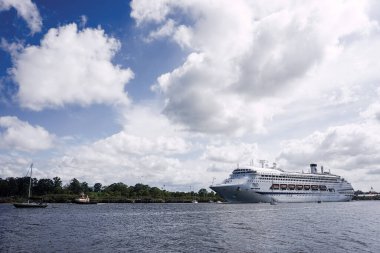 Corona virüsü covid-19 'un Avustralya' da ve uluslararası alanda pek çok gemiyi etkilemesinden önceki mutlu bir tatil yolculuğunun başlangıcında, Queensland Avustralya 'daki Brisbane Nehri' nde ilerleyen büyük beyaz bir yolcu gemisi.                    