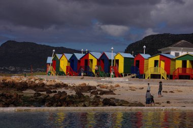 Güneşin bir parçasında parlayan bu parlak kırmızı, yeşil, mavi ve sarı renkler, bu değişen kulübeler Muizenberg, Güney Afrika 'daki St. James Sahili' nde yerel halk tarafından keyif alınıyor..                                              
