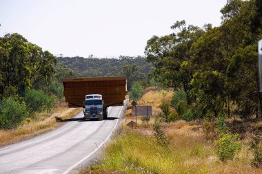 Queensland, Avustralya 'da yolun iki tarafını da kaplayan Peak Downs otoyolu boyunca taşınan dev kömür madenciliği kamyonu tepsisi..