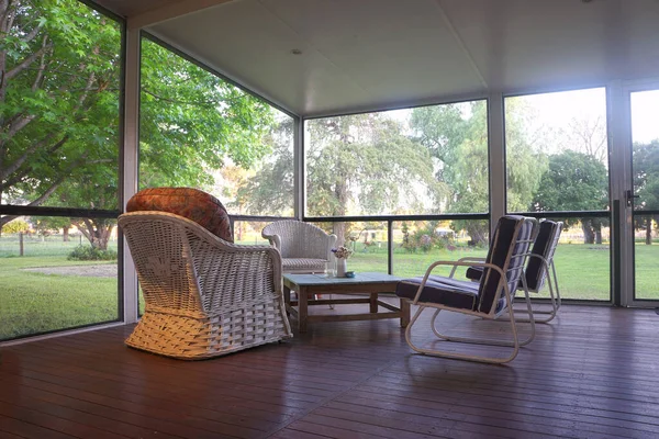 Öğleden sonra Queenslander evinin verandasında rahat sandalyeler..                               