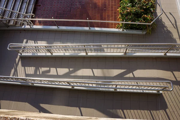 Renkli paslanmaz çelik korkuluklu rampa üzerindeki zigzag, Queensland, Townsville Avustralya 'daki bu binaya tekerlekli sandalye erişimi sağlıyor.. 