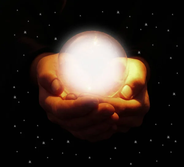未来を予測するために使用される星空の外に現れる明るい輝くクリスタルボールを保持する手 — ストック写真