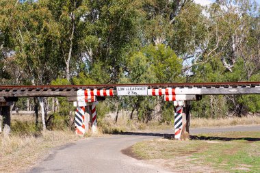 Güney Queensland, Avustralya 'daki bu kısıtlamalar köprüsünün altından geçen kırmızı ve beyaz uyarı işaretleri ve yükseklik göstergesi olan alçak seviye köprü..