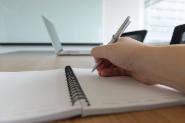 Bir defter ofiste onun sağ tarafta bir kalem kullanarak veya toplantı salonu adam