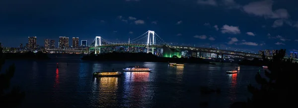 Panorama view of Rainbow bridge and Tokyo Bay with cityscape at night, Odaiba, Japan