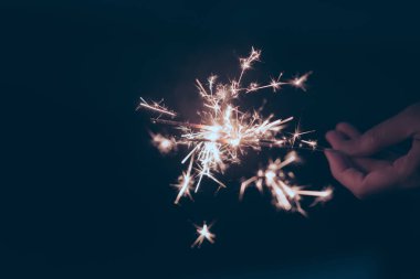 Neşeli Noel ve yeni yıl arifesinde gece arka plan - maytap parlak tutan eller