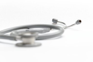 Beyaz tuval üzerine gri stetoskop tıbbi malzeme. Doktor araçları aygıtı. Tıp kavramı