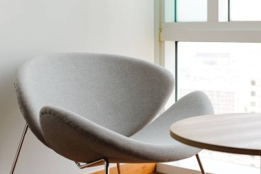 Modern sandalye ve masa oturma odasında pencere yakınındaki güneş ışığı ile.