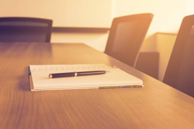 Not defteri üzerinde kalem için boş kurumsal konferans salonunda masada tutulması yapılacak işler