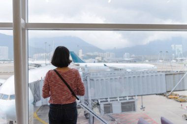 Arkadan görünüşü seyahat kız Uluslararası Havaalanı terminal penceresine yakınındaki ayakta