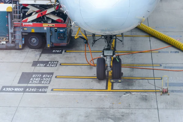 Airplane parked at airport terminal serviced by the ground crew preparing for a flight — Stock Photo, Image