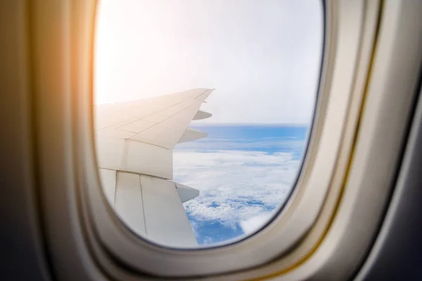 Wing of the plane flying above the clouds. View from the window of an airplane — Stock Photo, Image