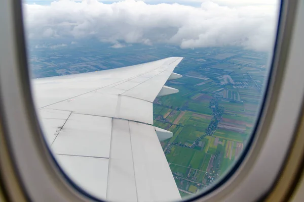 Ala del avión volando sobre las nubes. Vista desde la ventana de un avión — Foto de Stock