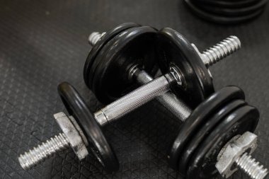 Spor salonunda siyah zeminde demir halter ler ya da ağırlıklar. Ağırlık Eğitim Ekipmanları. Sağlık kavramı.