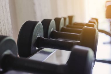 Spor salonunda rafa siyah dambıl sırası. Ağırlık Eğitim Ekipmanları. Sağlık kavramı.