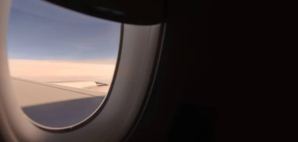 Vista dal finestrino dell'aereo che vola sopra le nuvole al tramonto — Foto Stock