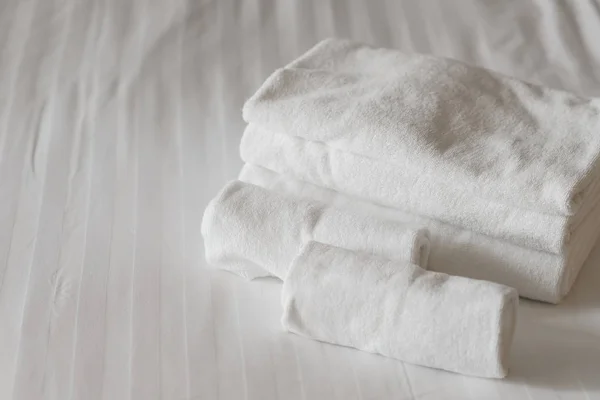 Toallas mullidas blancas en la cama en el dormitorio del hotel. Vista de cerca — Foto de Stock