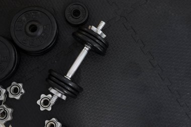 Metin için kopya alanı ile siyah zemin üzerinde Demir dambıl veya ağırlıkları üst görünümü. Düz döşeme kompozisyonu. Sağlık kavramı. 