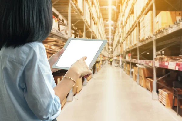 Manager vrouw met behulp van een Tablet PC met lege witte desktop scherm met in grote magazijn — Stockfoto