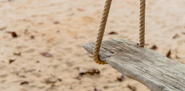 Close-up of Rope wooden swing hanging on tree at topical beach with sunlight in Thailand — Stock Photo, Image