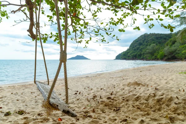 Rope wooden swing hanging on tree at topical beach with sunlight in Thailand — Stock Photo, Image