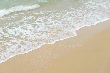 Kumlu sahilde denizde yumuşak dalga. Arka plan