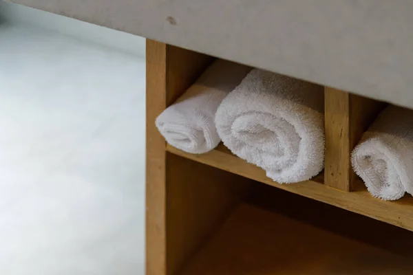 Rulla vita mjuka handdukar i inbyggd trähylla — Stockfoto