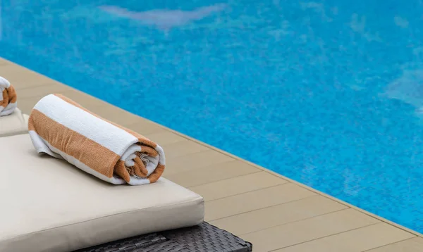 Rouleau serviette douce sur un transat près d'une piscine . — Photo