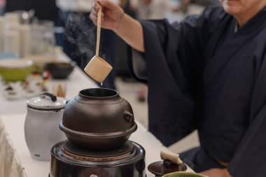 Japonlar bir gösteri sırasında yeşil çay hazırlıyorlar. Japon çay töreni.