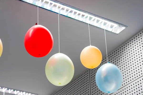 Veelkleurige ballonnen opknoping van kamerplafond voorbereid voor verjaardagsfeestje. — Stockfoto