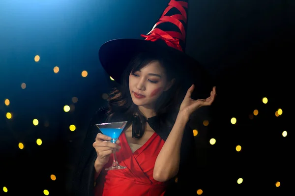 穿着女巫式万圣节服装的年轻漂亮女子在派对上喝鸡尾酒的画像 万圣节派对的概念 — 图库照片