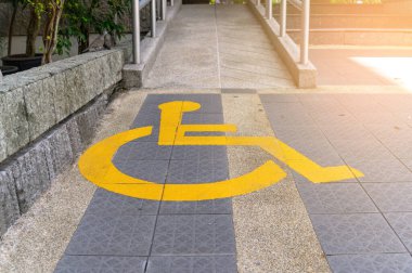 Sarı boyalı engelli trafik işareti. Rampanın önünde. Tekerlekli sandalye desteği için.