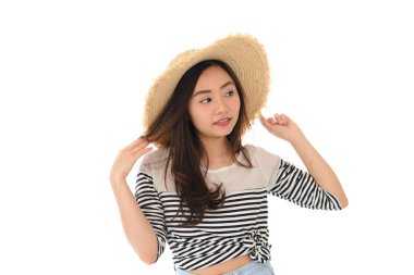 Beyaz arka planda izole edilmiş hasır şapka ve yaz elbisesi içinde gülümseyen mutlu Asyalı genç kadın portresi. Boş zaman ve yaz seyahati konsepti