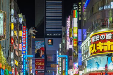 TOKYO, JAPONYA - 8 Nisan 2025: Shinjuku 'da bir Toho sinemasının tepesindeki Godzilla baş heykelinin gece görüntüsü