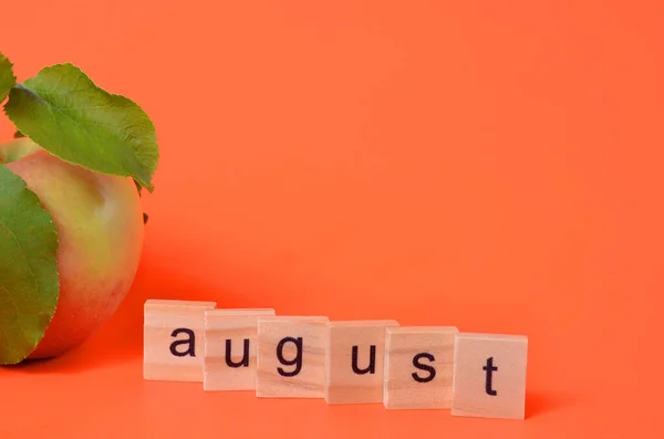 Apple Een Oranje Achtergrond Maand Augustus Geschreven Houten Letters Kalender — Stockfoto
