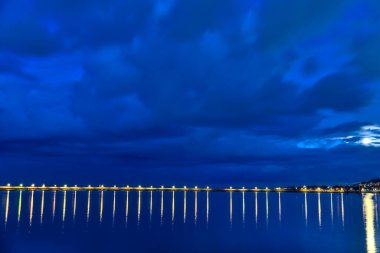 Akşamları Harbor 'ın fenerleri yanıyor. Sudaki ışığın yansıması. Mavi saatte Dun Laoghaire limanı. Doğu İskelesi. Dublin, İrlanda 'daki ünlü limanın akşam çekimleri