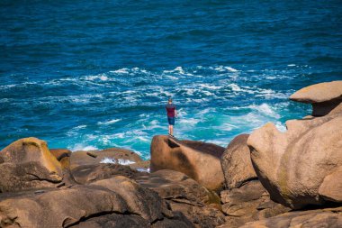 Fransa 'nın Brittany bölgesindeki Ctes-d' Armor 'daki Mean Ruz deniz feneriyle Ploumanac' h 'h' daki pembe granit sahil..
