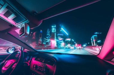 Car speed drive on the road in night city. Retro wave neon noir lights color toning clipart