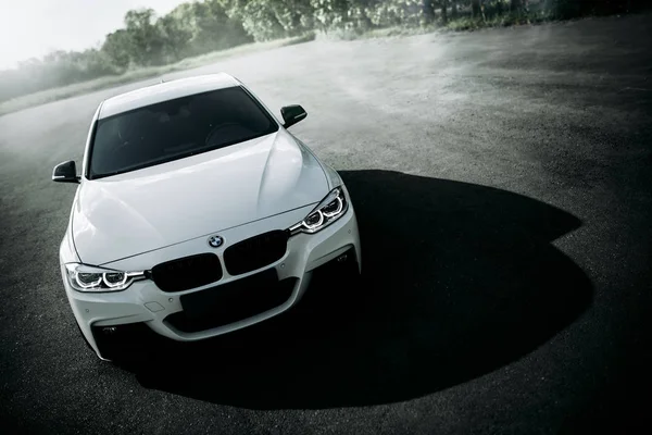 Engels, Rusya Federasyonu - 04 Haziran 2018: Beyaz araba Bmw 3 Serisi F30 gündüz boş kırsal asfalt yolda duruyor