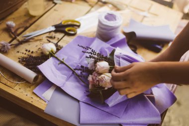 Kadın gül çiçek buketi ahşap masa üzerinde işçiliği