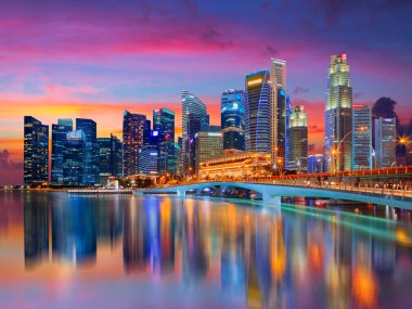 Singapur şehir silüeti manzarası. İşletme bölge görünümü. Marina Bay Pembe günbatımında suya yansıyan şehir merkezinde. Cityscape seyahat