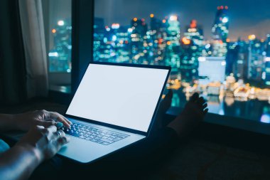  Kadın freelancer dizüstü bilgisayarla ev ofis geceleri çalışıyor. Hava şehir manzarası Görünümü penceresinden. Serbest yaşam tarzı