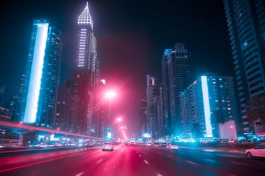 Geceleri, Birleşik Arap Emirlikleri Dubai Şeyh Zayed Rd bir araba sürüş. Bulanık hareket. Çift ton retro dalga neon noir ışıklar renk tonlu