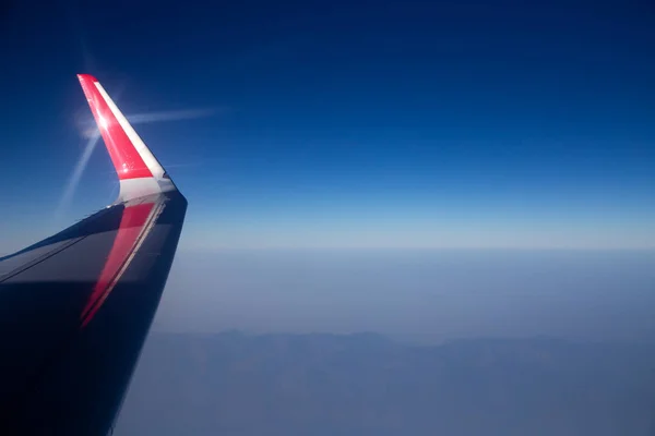 Vista aérea do avião. Céu azul e asa plana na janela — Fotografia de Stock